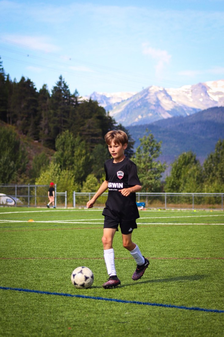 A player driving with the ball, mountains behind